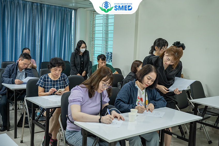 Tư vấn viên tại SMED hướng dẫn mọi người điền thông tin thăm khám miễn phí tại CS1